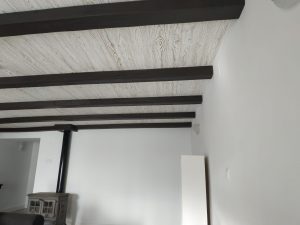 Salón con vigas oscuras sobre techo claro