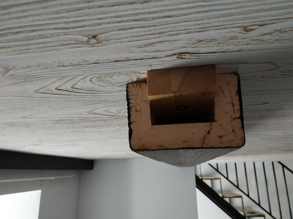 Extremo de una viga hueca de poliuretano imitación madera blanqueada